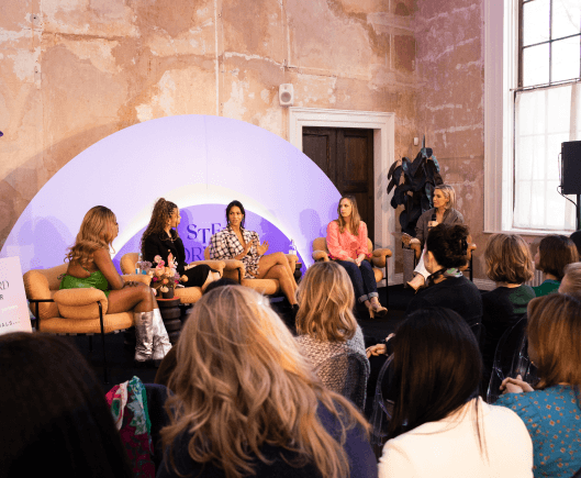 An audience sat watching a panel of speakers engaged in conversation with each other