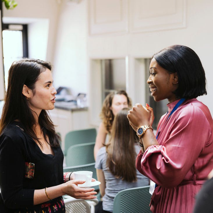 two women talking at a networking event